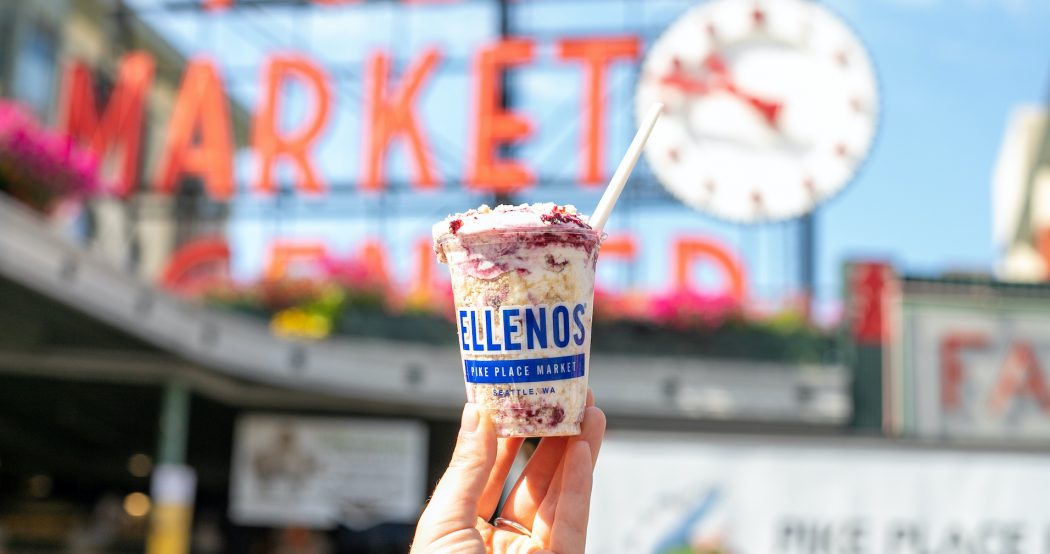 Walkaround cup of Ellenos Greek yogurt at Pike Place Market scoop shop, in front of the iconic Pike Place Market sign